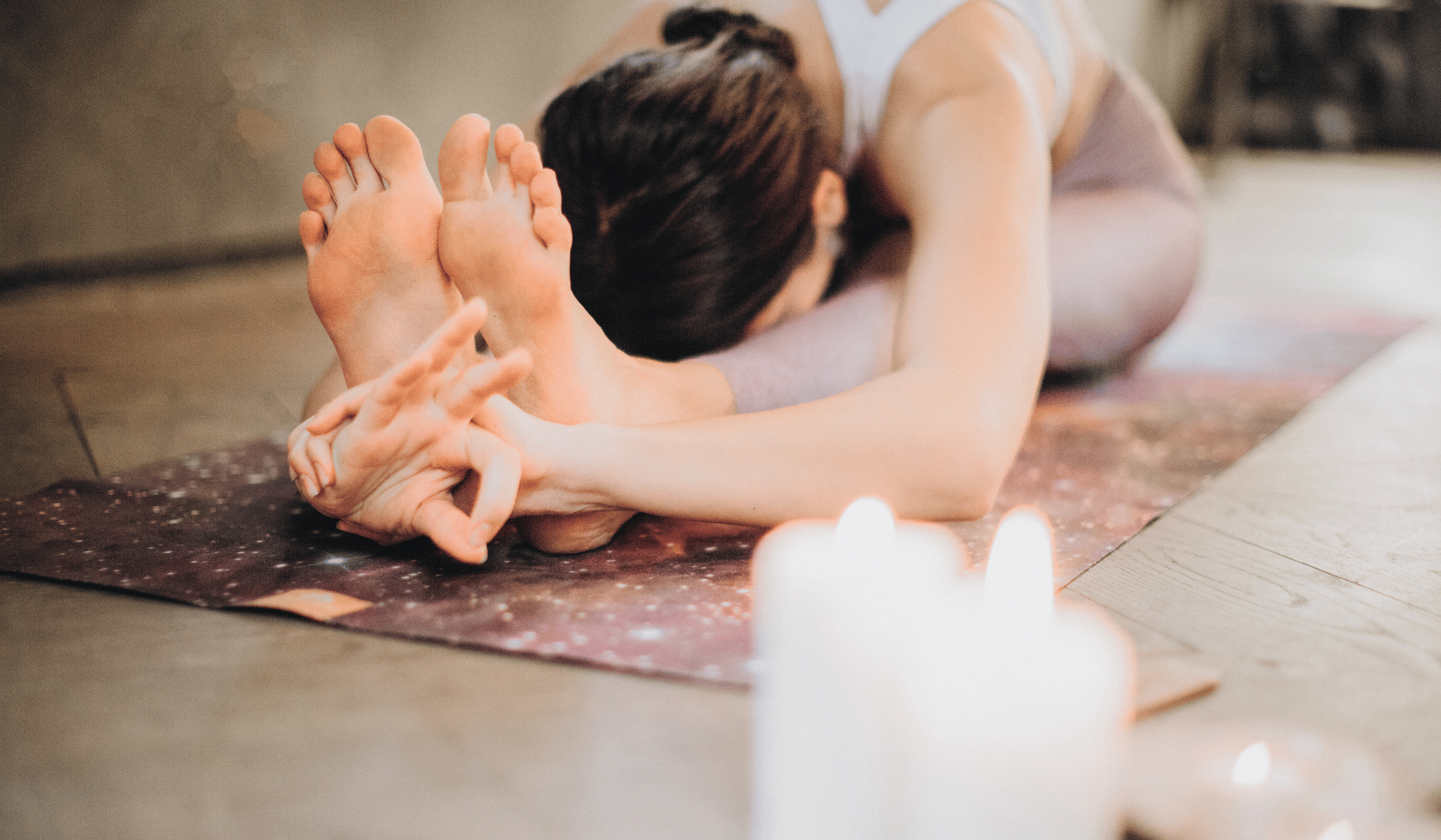 Woman practicing a forward fold yoga pose on her mat.