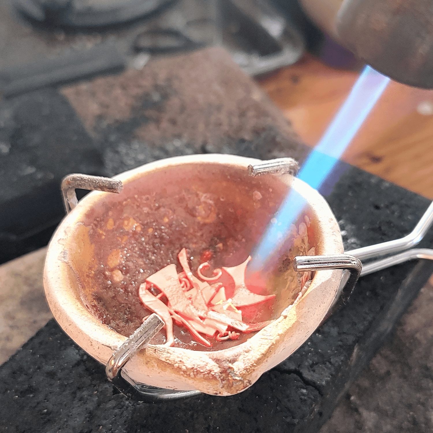 Melting scrap silver in a crucible.